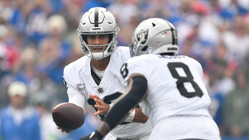 Las Vegas Raiders quarterback Jimmy Garoppolo, left, hands the ball to running back Josh...