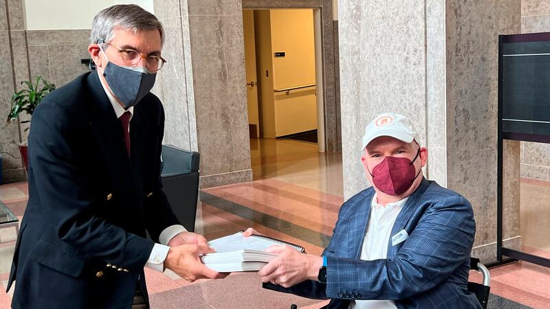 In this photo provided by I AM ALS, Dan Tate, right, delivers a printed petition from ALS...