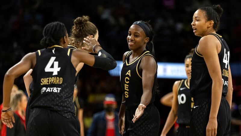 Las Vegas Aces guard Aisha Sheppard (4) slaps hands with guard Jackie Young, center, during...