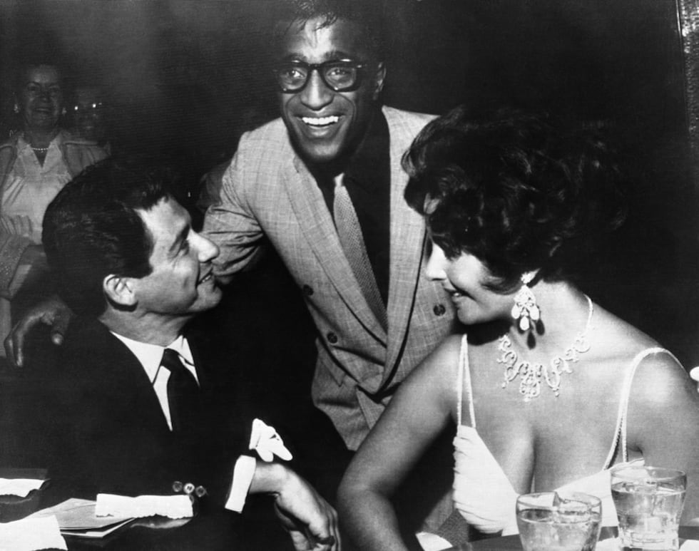 Elizabeth Taylor, right, and Eddie Fisher, left, discuss wedding plans with Sammy Davis, Jr....
