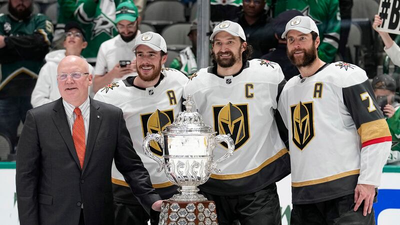 From left to right, Bill Daly, deputy commissioner of the NHL, presents the trophy to Vegas...