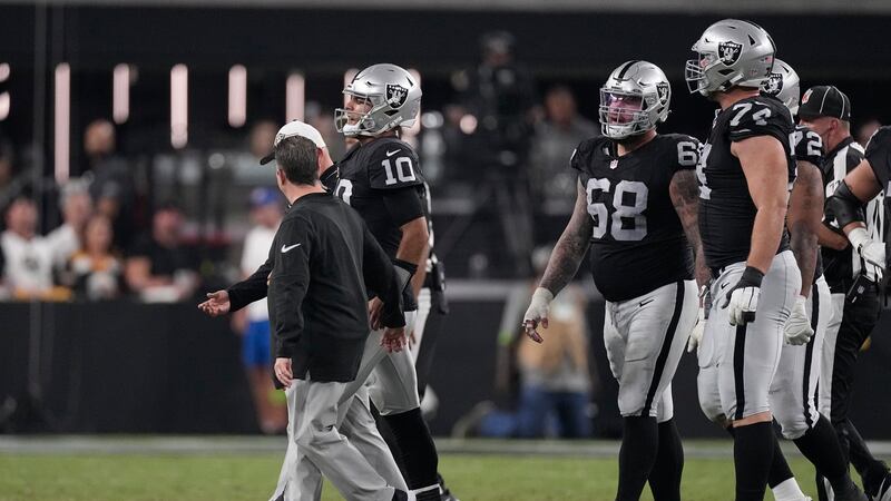 Las Vegas Raiders quarterback Jimmy Garoppolo is helped off the field after being sacked by...