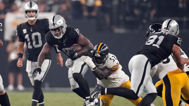 Las Vegas Raiders running back Josh Jacobs, center, is tackled by Pittsburgh Steelers...