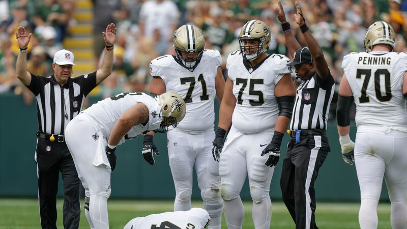 Saints quarterback Derek Carr lays on the turf with an AC sprain injury after being sacked in...