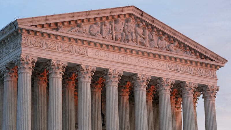 The setting sun illuminates the Supreme Court building on Capitol Hill in Washington, Tuesday,...